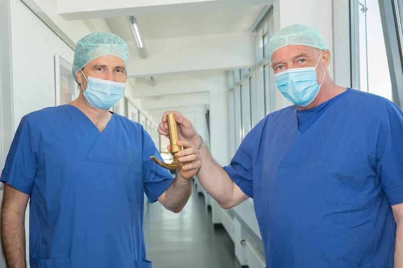 Amtsübergabe an der Klinik für Anästhesiologie und Operative Intensivmedizin des UKB: Prof. Andreas Hoeft (re) übergibt das Zepter symbolisch in Form eines vergoldeten Laryngoskops an seinen Nachfolger Prof. Mark Coburn (li).