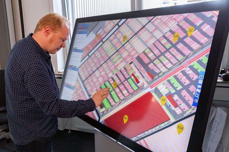 Michael Görges, Isabella project manager of BLG LOGISTICS, demonstrates the multitouch table in test use at the Bremerhaven auto terminal. Different simulation-based planning scenarios can also be presented via this medium.