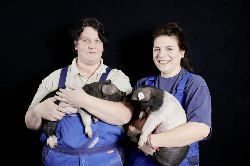 Marianne Zenk (li.) und Dr. Corinna Gladbach vom FBN mit Ferkeln aus der gefährdeten Rasse der deutschen Sattelschweine.