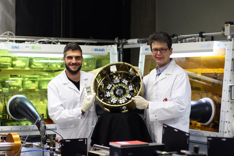 Prof. Dr. Peter Müller-Buschbaum (right) and Lennart Reb in the laboratories of the Professorship of Functional Materials at the Technical University of Munich with the payload module “Organic and Hybrid Solar Cells In Space” (OHSCIS).