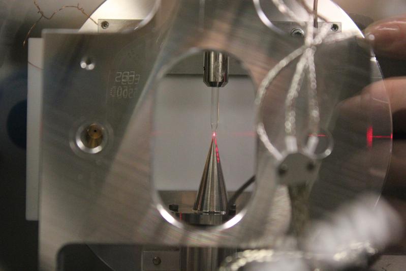 Die Wissenschaftler spritzen von oben Wasser in die Analysekammer, wo es einen kurzen Mikrostrahl bildet, auf den ein Laserpuls trifft. 