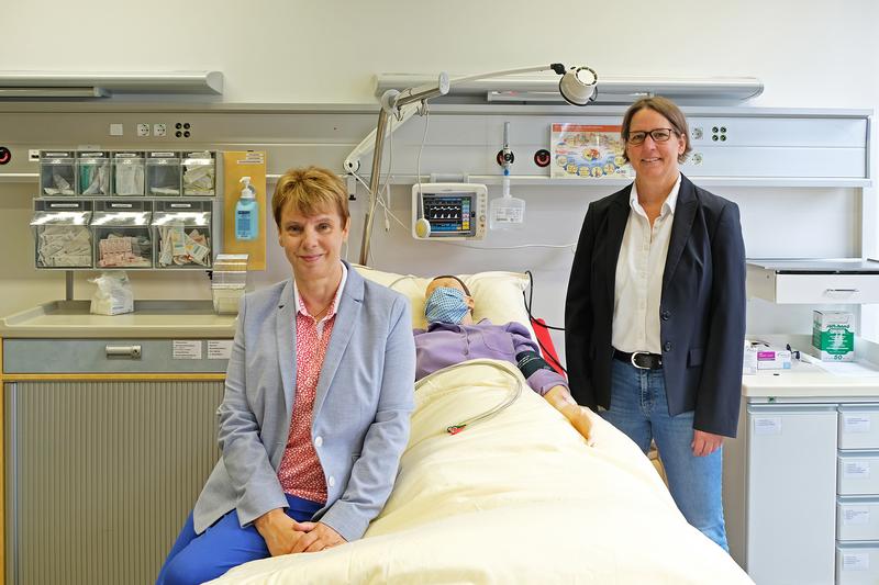 Prof. Dr. Christa Büker (links) und Prof. Dr. Änne-Dörte Latteck im Skills Lab der FH Bielefeld, in dem Studierende des neuen Studiengangs pflegerische Handlungen planen und üben können.