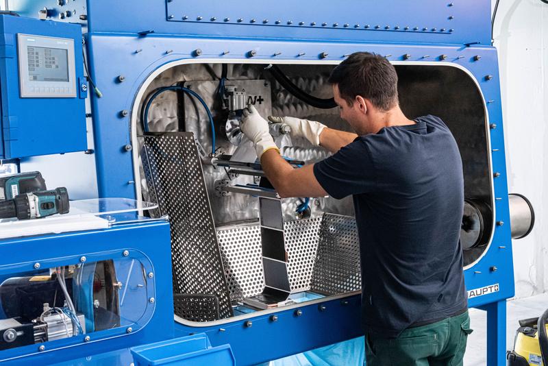 Ein Kyburz-Mitarbeiter bedient die neue Recyclinganlage für Lithium-Ionen-Akkus.