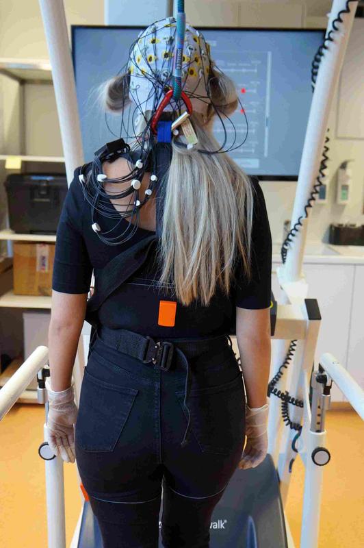Im Brain-Imaging-Lab geht eine Probandin mit EEG-Haube auf dem Laufband