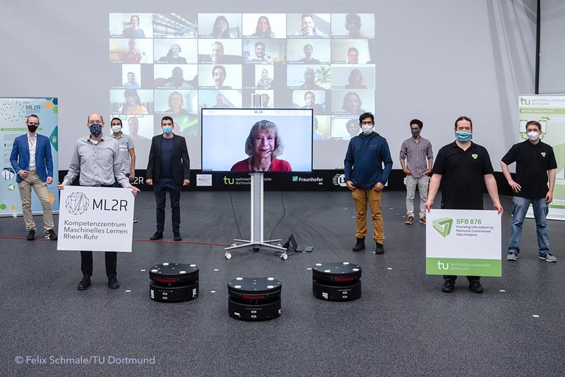 Conclusion and highlight of the Summer School: a live broadcast from the Dortmund logistics hall. The finalists of the hackathon were allowed to control the logistics robots from a distance and steer them over the test field. 