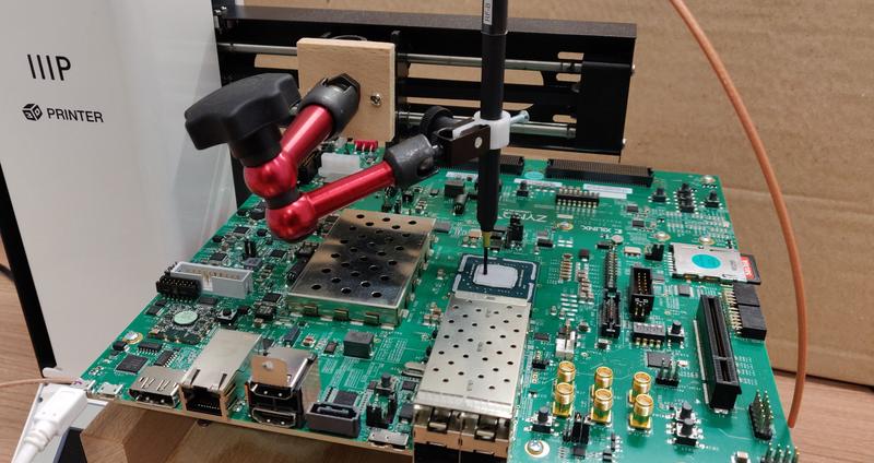 Trial set-up for the detection of the "moving target" by measuring electromagnetic currents on a FPGA with a probe that is held by a 3D printer.