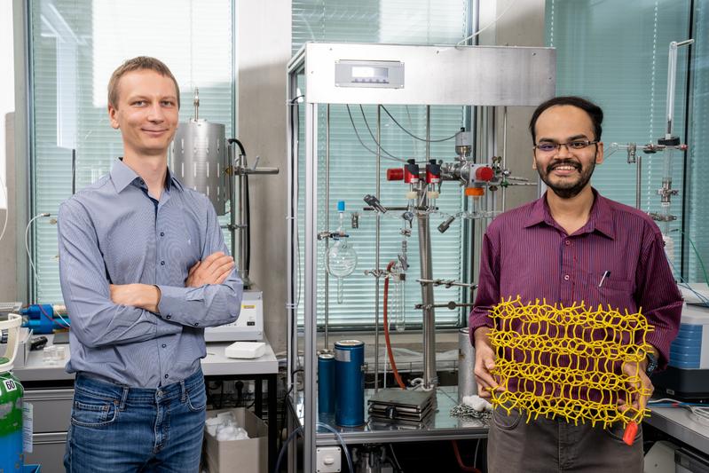 PSI-Forscher Vitaly Sushkevich (links) und Manoj Ravi, Doktorand der ETH Zürich, im PSI-Labor. In seinen Händen hält Ravi das Modell eines Zeolithgerüsts. 