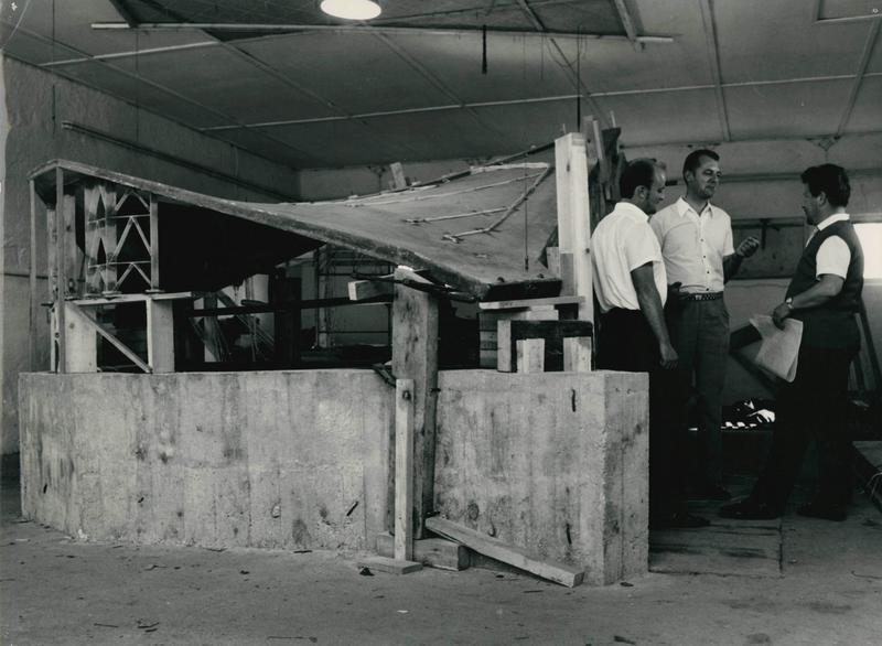 Modellstatische Untersuchung im „Spezi-Bau Binz“ im Jahr 1969 mit der Versuchsschale der Messe- und Kongresshalle Rostock. In der Mitte ist der junge Ulrich Müther zu sehen. 