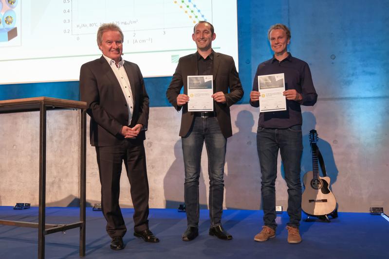 The f-cell Award was presented by Baden-Württemberg's Environment Minister Franz Untersteller (left) to Dr. Roman Keding (center) and Dr. Matthias Klingele.