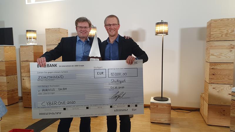 Dr. Stefan Hörmann und Martin Bach (rechts) freuen sich über den CyberOne-Preisscheck in Höhe von 10 000 Euro