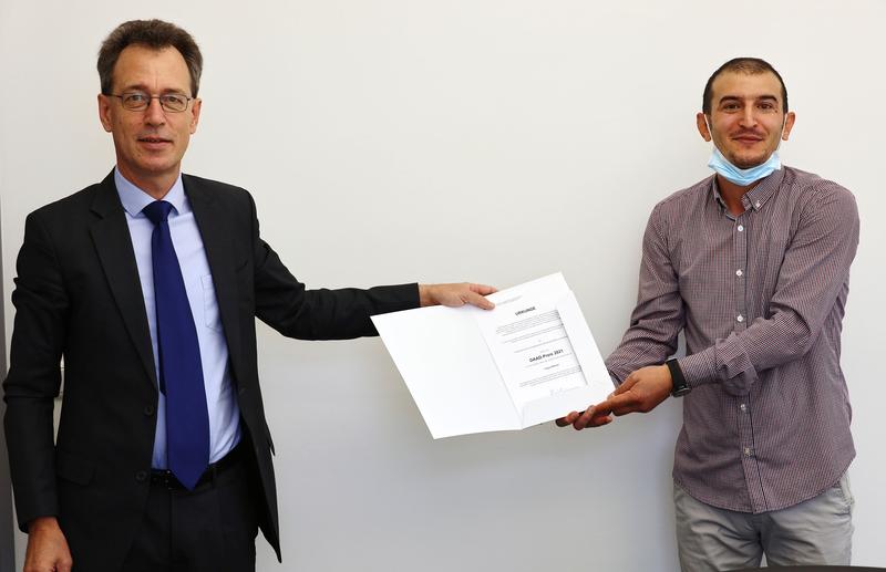 Der Hochschulpräsident Prof. Dr. Fritz Pörnbacher überreichte Fayez Alkhalil die DAAD-Preis-Urkunde.