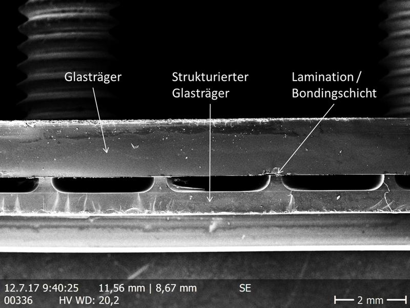 Rasterelektronenmikroskop-Aufnahme eines Querschnitts (Bruchkante) durch einen laminierten Glasträger mit strukturiertem Glasträger.