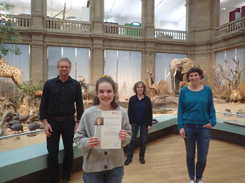 Prof. Dr. Bernhard Misof, Dr. Mariam Gabelaia mit der Urkunde, Prof. Dr. Heike Wägele, Dr. Julia Schwarzer(vlnr) im Ausstellungsteil „Savanne“, dem zentralen Lichthof des Museums