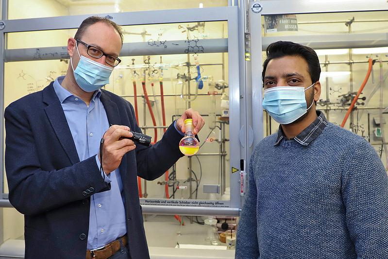 Angestrahlt: In dem Reagenzglas, das Professor Daniel B. Werz und Dr. Atanu Patra zeigen, befinden sich fluoreszierende Moleküle, die sie gebaut haben.