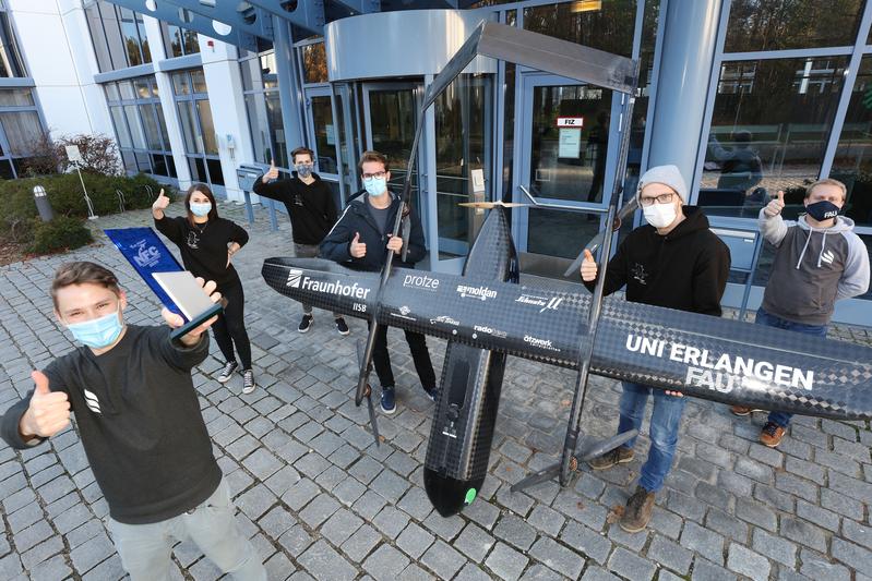 Team TechFak EcoCar mit dem Pokal für den 1. Platz beim NFC 2020 und dem elektrischen VTOL-Copter "Night Fury" vor dem Fraunhofer IISB in Erlangen