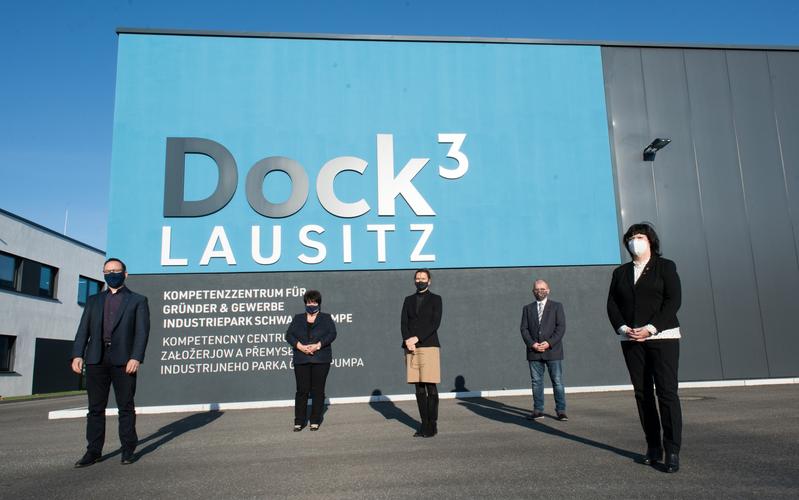 Gruppenfoto der Kooperationspartner*innen vor dem Kompetenzzentrum für Gründer & Gewerbe „Dock3 Lausitz“. 