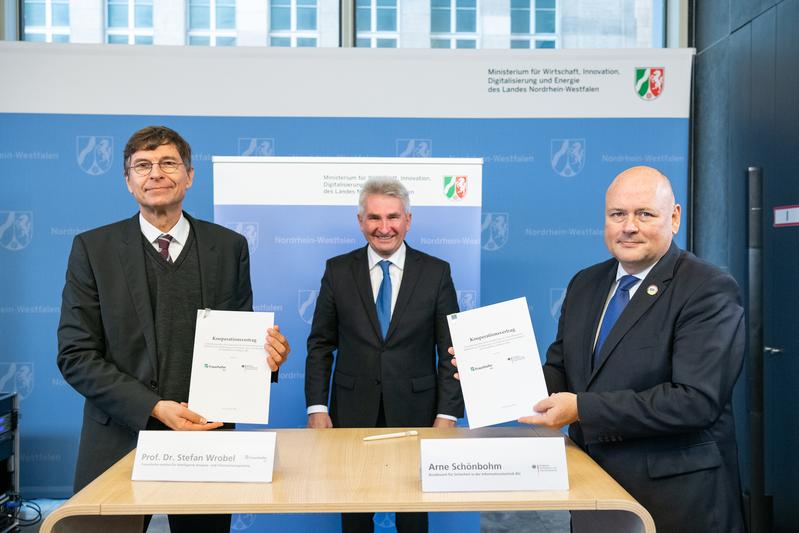 Im Beisein von NRW-Digitalminister Prof. Dr. Andreas Pinkwart (Mitte) haben BSI-Präsident Arne Schönbohm (rechts) und Prof. Dr. Stefan Wrobel, Leiter des Fraunhofer IAIS, eine Kooperationsvereinbarung unterzeichnet.