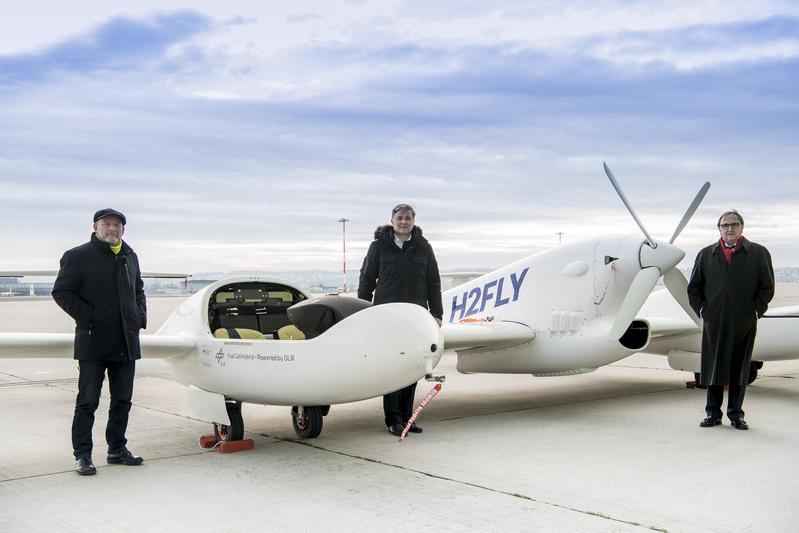 Verkehrsminister Winfried Hermann, Hy4-Projektleiter Prof. Josef Kallo (Uni Ulm/DLR) und Flughafengeschäftsführer Walter Schoefer (v.l.)  bei der Präsentation der neuesten Generation des  Wasserstoff-Flugzeugs Hy4 am Flughafen Stuttgart