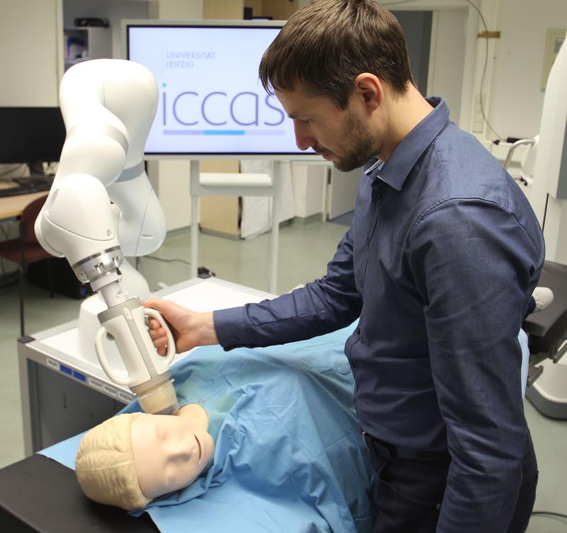 Demonstrator of a robotic system for combined ultrasound radiotherapy developed at ICCAS, consisting of a KUKA LBR Med robot arm with attached treatment head.