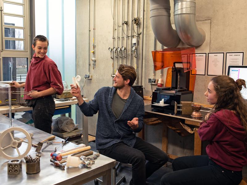 Studierende (v.l.n.r. Svea Finck, Aleksander Rasztawicki, Noa Domínguez Rama) der Fakultät Gestaltung in der Schmuckwerkstatt am 3D-Drucker.