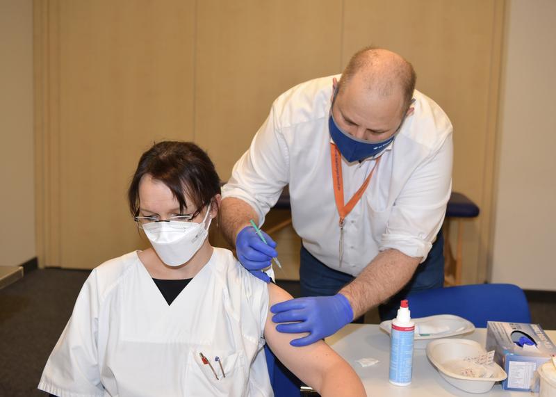 Bild (Vorschau): Eine Mitarbeiterin des Bergmannsheils erhält ihre erste Schutzimpfung gegen das Corona-Virus durch den Betriebsarzt der Klinik, Dr. Ingolf Hosbach