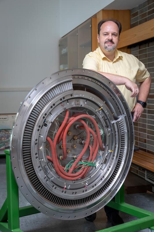 TU Graz-Forscher Emil Göttlich mit dem Turbine Center Frame – einem zentralen Bauteil einer Flugzeugturbine und Forschungsgegenstand am Institut für Thermische Turbomaschinen und Maschinendynamik der TU Graz.