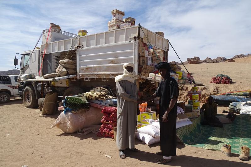 The market of Bardai. This trader sells onions, mattresses, biscuits, sweets, canned food, guava juice, milk powder, mats, tea, cement, sugar, cheese, and prayer rugs, among other things. Many goods are imported via Libya. 