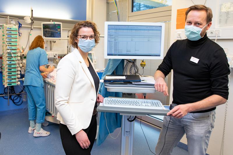 Dr Thomas Jack and Dr Antje Wulff next to a PDMS monitor in the paediatric intensive care unit. 