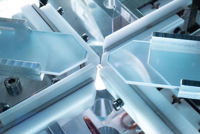 Inside a vacuum chamber, physicists of the Max Planck Institute of Quantum Optics trap a single atom with two crossing optical resonators. They are each made of two optical fibres which are visible in the crossing point. 