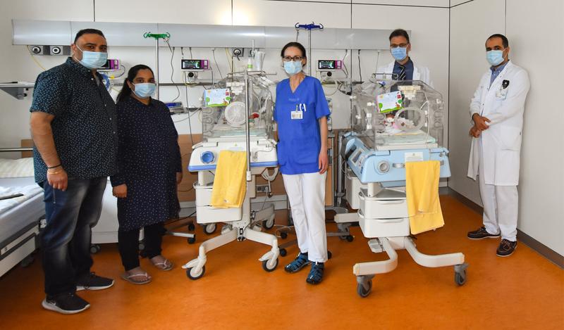 Puneet (l.) und Soni freuen sich über die Geburt ihrer Kinder Avik und Maira, die noch im Inkubator versorgt werden. Das Ärzteteam um OÄ Dr. Barbara Seipolt, Prof. Mario Rüdiger und OA Dr. Cahit Birdir (r.) hat die Geschwister zur Welt gebracht.