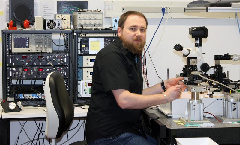 Dr. Peter Machnik in one of the laboratories at Animal Physiology at the University of Bayreuth. In the background: Set-up for the electrophysiological study of nerve cells in the brains of fish.