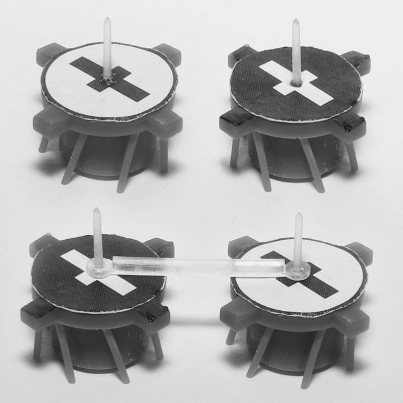 Die Miniaturroboter aus dem 3D-Drucker, die auf einem Vibrationsteller in Drehung versetzt werden können; der Winkel der Beinchen bestimmt ihre Drehrichtung. Unten sind zwei unterschiedlich drehende Roboter verkettet.