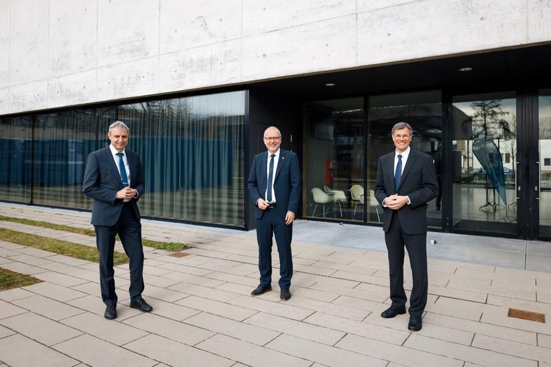 Dr. Karl Lamprecht (rechts), Vorsitzender des Hochschulrats, gratuliert Prof. Dr. Harald Riegel (Mitte) zur Rektorwahl. Der Physiker wird ab 2022 Nachfolger von Prof. Dr. Gerhard Schneider.