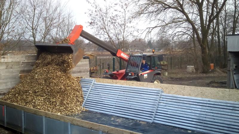 Aufschütten der Miete mit feuchten Holzhackschnitzeln auf einer Versuchsplattform und innenliegendem Lüftungskanal 