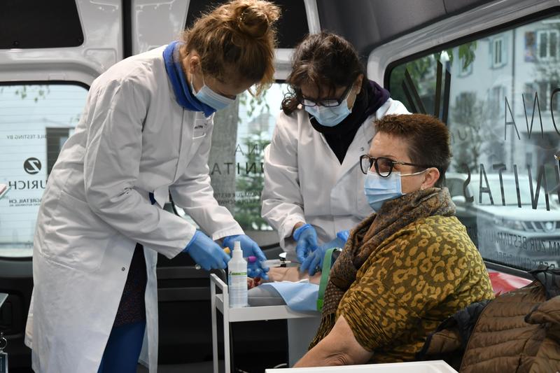 Swiss TPH Study Nurses nehmen einer Studienteilnehmerin Blut für den Antikörpertest ab