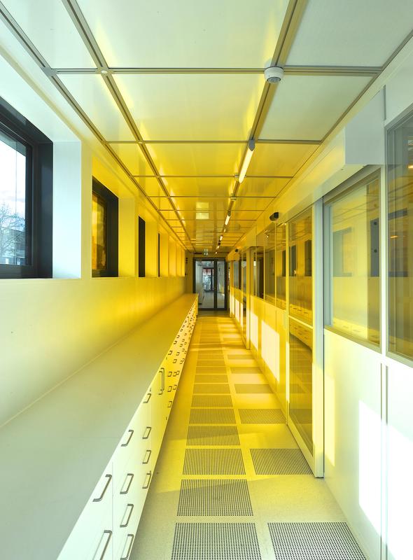 Center for High Efficiency Solar Cells: View into the corridor of the clean room. In the back one can see the yellow light from the photolithography laboratory.