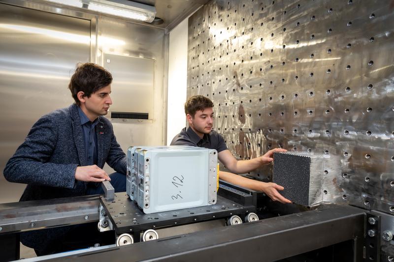 Untersuchungen der TU Graz zeigen: Batterien von E-Autos werden unterm Strich sicherer mit dem Alter. Im Bild: Projektleiter Christian Ellersdorfer mit Kollegen Christian Trummer bei der Batterien-Crashanlage des Battery Safety Center Graz. 