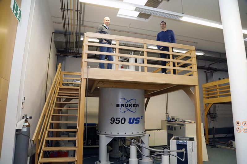 Scientists Martin Hengesbach (left) und Andreas Schlundt at the nuclear magnetic resonance (NMR) spectrometre at Goethe-University Frankfurt, Germany