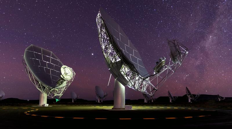 Radioantennen des MeerKAT-Teleskopnetzwerks in der Karoo-Halbwüste in Südafrika unter dem nächtlichen Sternenhimmel.