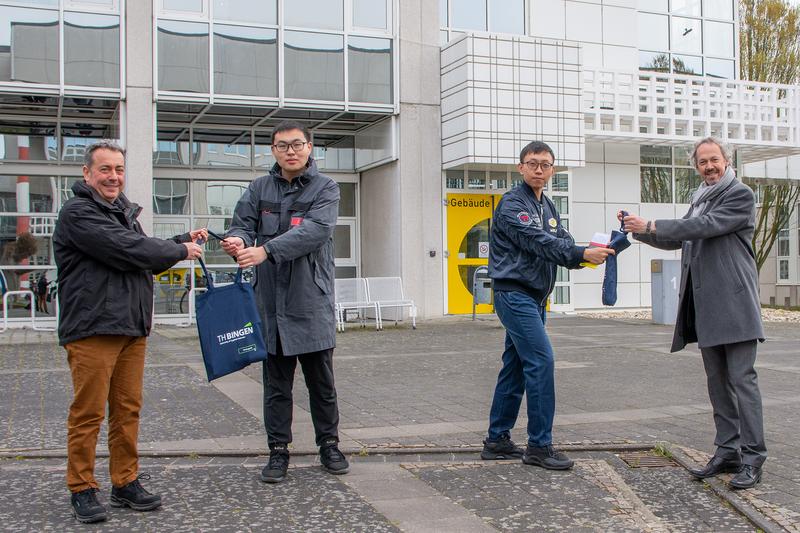 TH-Vizepräsident Prof. Dr. Michael Rademacher (links) und Prof. Dr. Oliver Türk (rechts) überreichen den chinesischen Austauschstudenten Ma Boyang und Xu Haoyang (v. l. n. r.) ein Begrüßungsgeschenk.