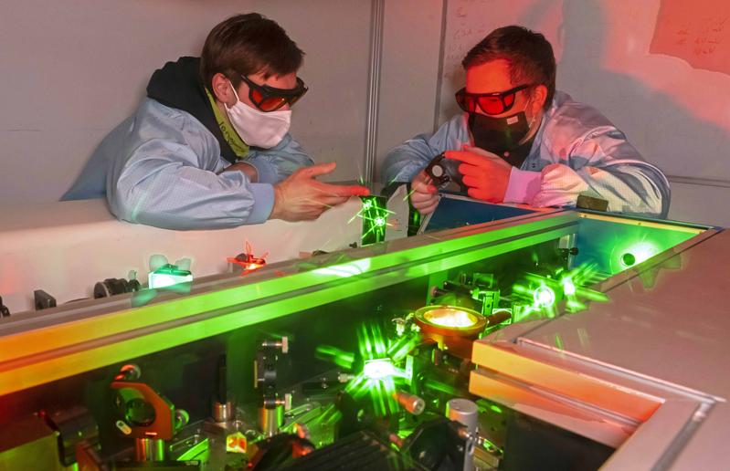 Erstautor der aktuellen Studie Tobias Helk (l.) und Dr. Frederik Tuitje in einem Laserlabor der Universität Jena.