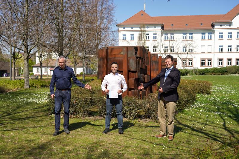 Prof. Dr. Holger Paschedag (Vizepräsident Studium, Lehre und Internationales, links) und Prof. Dr. Konrad Mußenbrock (Dekan der Fakultät IW, rechts) gratulieren dem erfolgreichen Absolventen