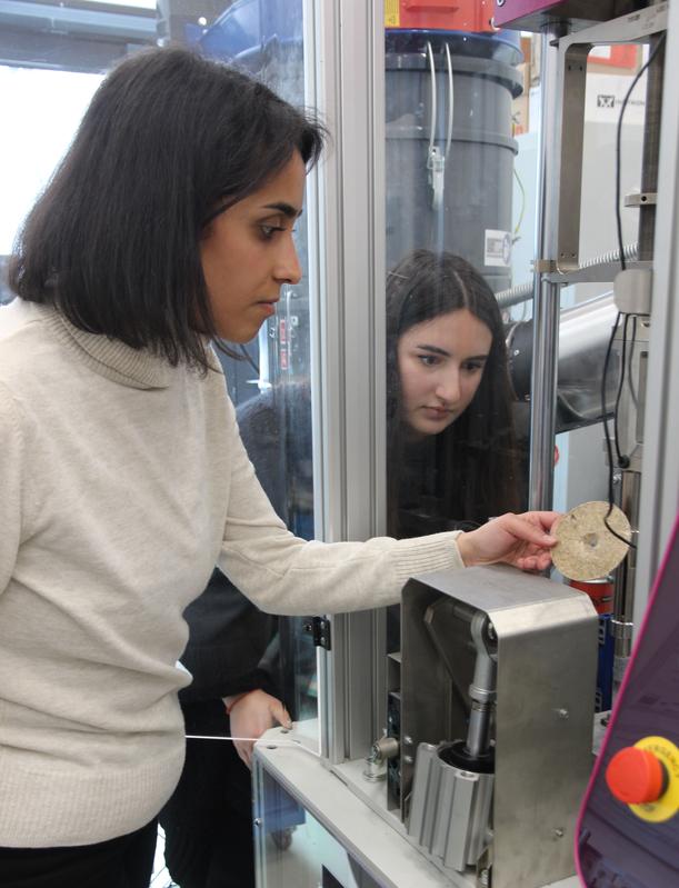 Ist der Werkstoff Vulkanfiber für Gehäuse zukünftiger Batteriegenerationen geeignet? Im Labor untersuchen die wissenschaftlichen Mitarbeiterinnen Kardelen Bayram (vorne) und Lea Aydin dessen Crashtauglichkeit. 