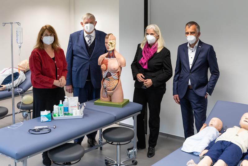 Rektor Sagerer (r.) und Gründungsdekanin Hornberg (l.) führen Minister Laumann und Ministerin Pfeiffer-Poensgen durch einen Raum im „Skills Lab“ im Gebäude R.1 an der Morgenbreede. In diesem Bereich trainieren die Studierenden praktische Fertigkeiten.