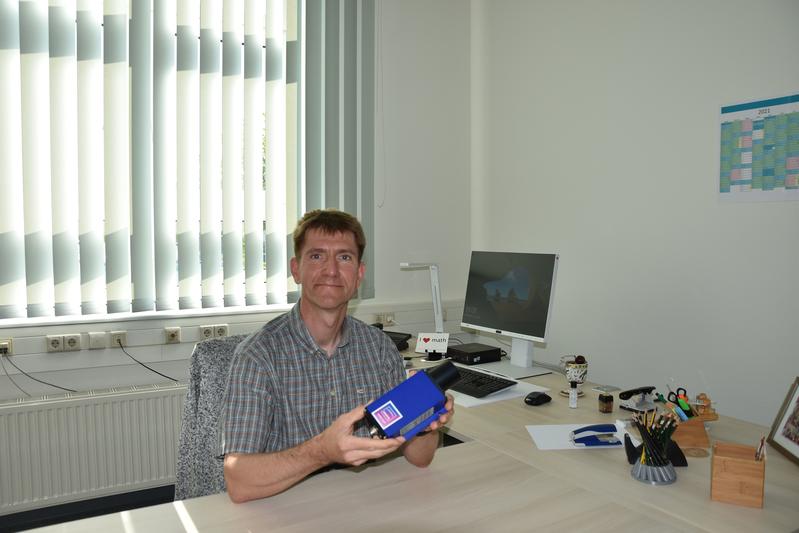 Dekan Prof. Dr. André Große mit dem Laser-Entfernungsmesser 