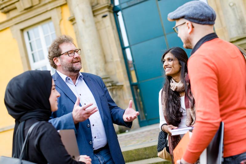 Studiengangsleiter Dr. Michael Kiefer im Gespräch mit Studierenden. Zum Wintersemester startet der neue Masterstudiengang „Soziale Arbeit in der Migrationsgesellschaft mit dem Schwerpunkt muslimische Wohlfahrtspflege“ an der Universität Osnabrück.