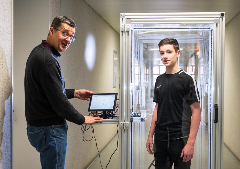 Prof. Andreas Schütze (l.) zeigt, wie Schüler bei SUSmobil Umweltsensorsysteme kennenlernen: Bei diesem Versuchsaufbau können sie auf dem Tablet-Computer mitverfolgen, wie sich die Luftqualität in der Kabine verändert, wenn sich ein Schüler darin aufhält.