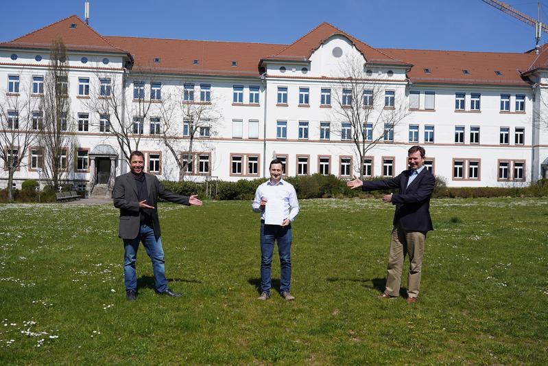 Studiengangsleiter Prof. Dr.-Ing. Michael Mann (li) und Prof. Dr. Konrad Mußenbrock (Dekan der Fakultät IW (re)) gratulieren dem erfolgreichen Absolventen