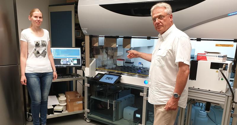 Dr. Franziska Haag (l) und PD Dr. Dietmar Krautwurst vor dem Hochdurchsatz-Pipettier- und Messroboter (TECAN Fluent®). Mit dem Gerät untersuchen Forschende des LSB, auf welche Geruchsstoffe menschliche Geruchsrezeptoren reagieren.