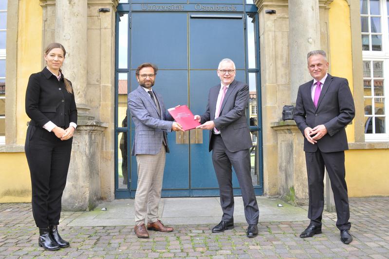 Direktor Prof. Bülent Ucar überreichte Staatssekretär Dr. Frank-Thomas Hett zusammen mit Universitätspräsidentin Prof. Dr. Susanne Menzel-Riedl und Projektleiter Dr. Esnaf Begic den Abschlussbericht.